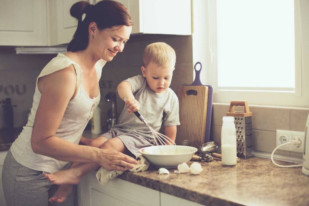 Mother and child baking together in kitchen.