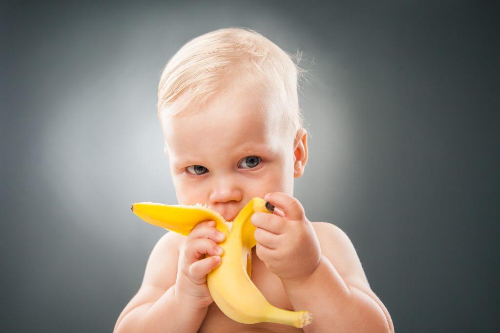 Baby eating a banana.