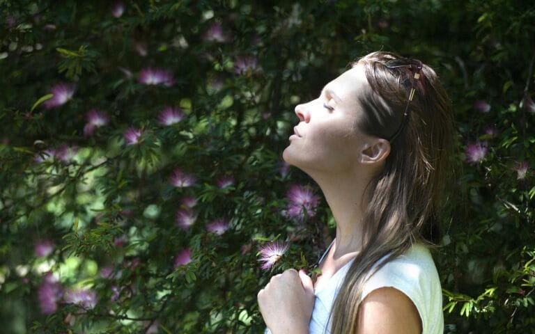 Woman enjoying sunlight in flower garden