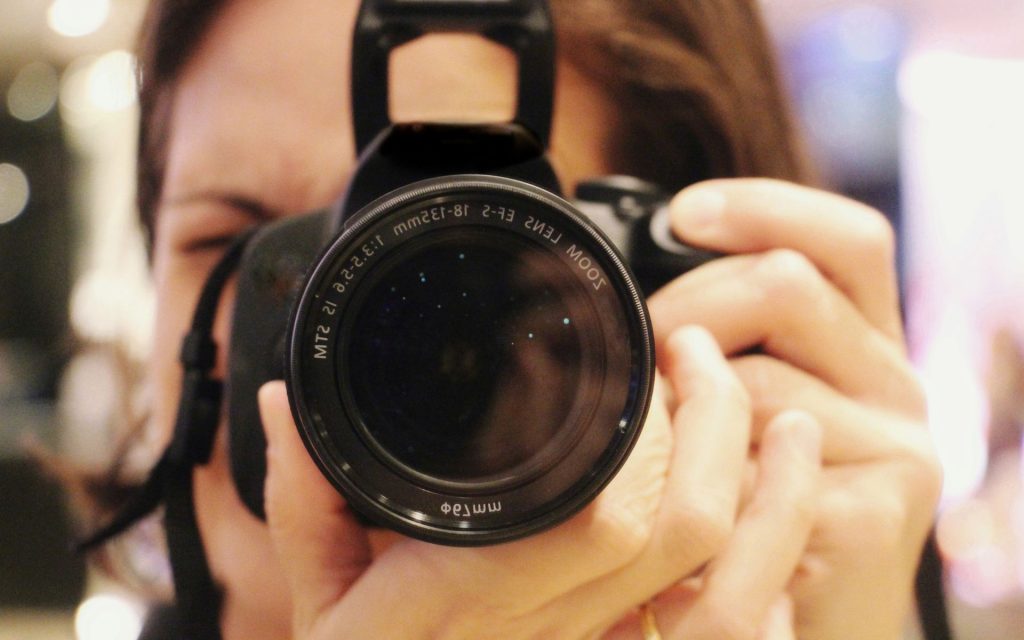 family photographer holds camera up to her eye
