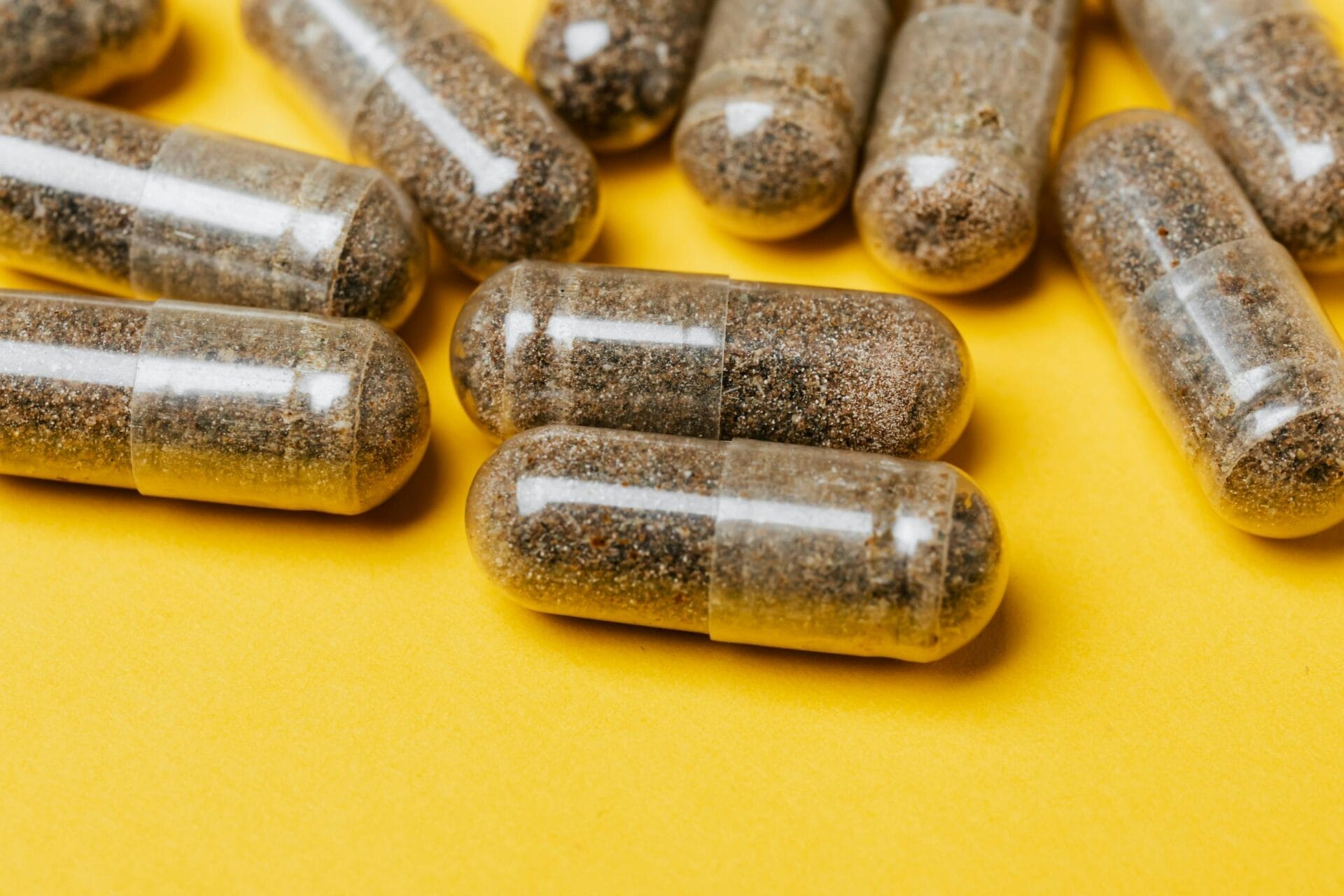 Close-up of clear capsules on a vibrant yellow surface, offering potential for health-related content