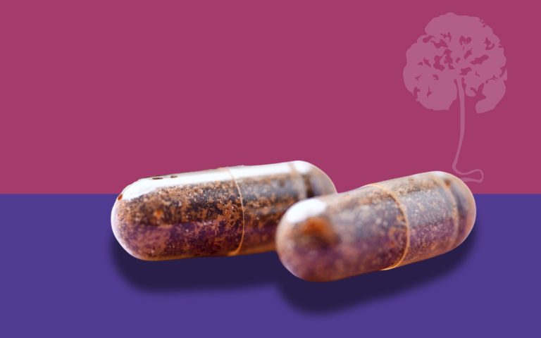 Placenta capsules on a pink and purple background from a placenta encapsulation service in San Antonio, TX