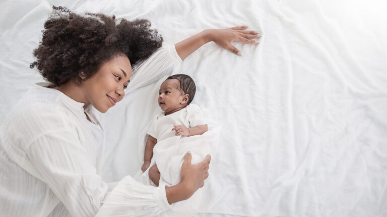 a mother snuggles her baby after taking her placenta capsules.